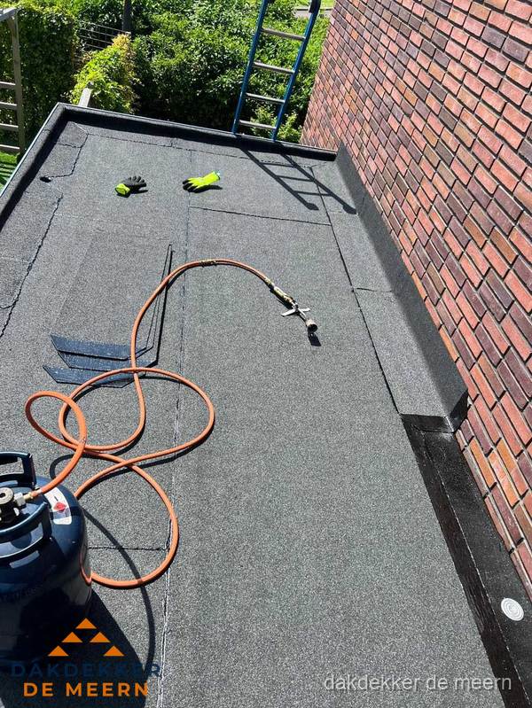 Plat dak met bitumen en brandgereedschap van dakdekkersbedrijf in De Meern