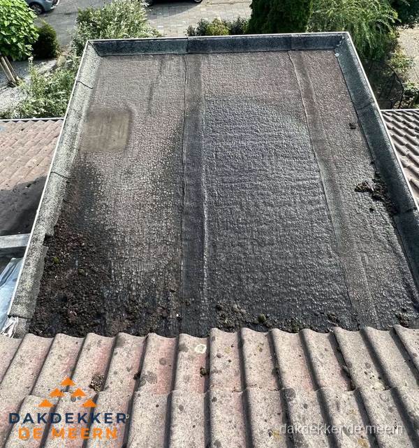 Verouderd plat dak met bitumen en slijtage voor lekkage inspectie in De Meern Verouderd plat dak met bitumen en slijtage voor lekkage inspectie in De Meern