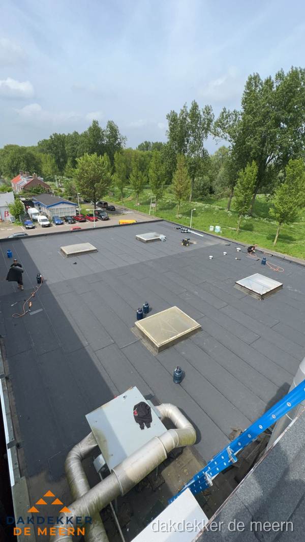 Dakdekker aan het werk op groot plat dak met bitumen in De Meern Dakdekker aan het werk op groot plat dak met bitumen in De Meern