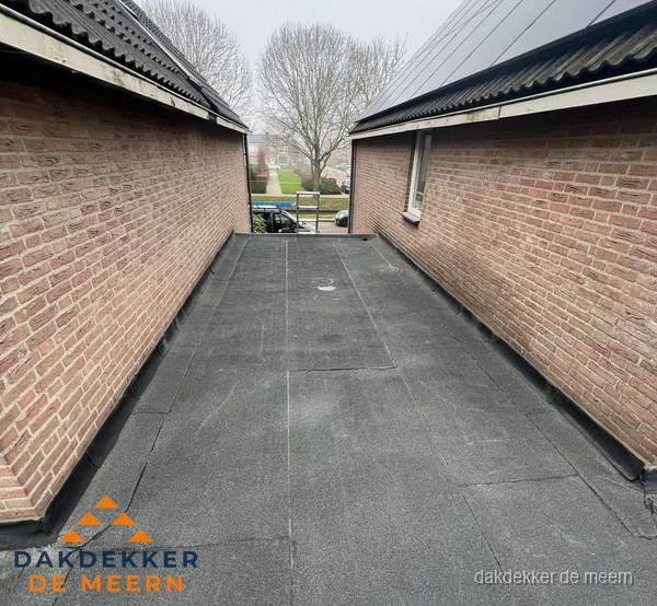 Plat dak met bitumen dakbedekking tussen bakstenen muren in De Meern Plat dak met bitumen dakbedekking tussen bakstenen muren in De Meern