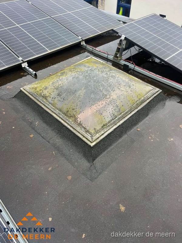 Vervuilde lichtkoepel op plat dak met zonnepanelen in De Meern Vervuilde lichtkoepel op plat dak met zonnepanelen in De Meern
