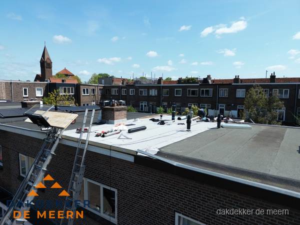 Dakdekkers aan het werk op plat dak in De Meern